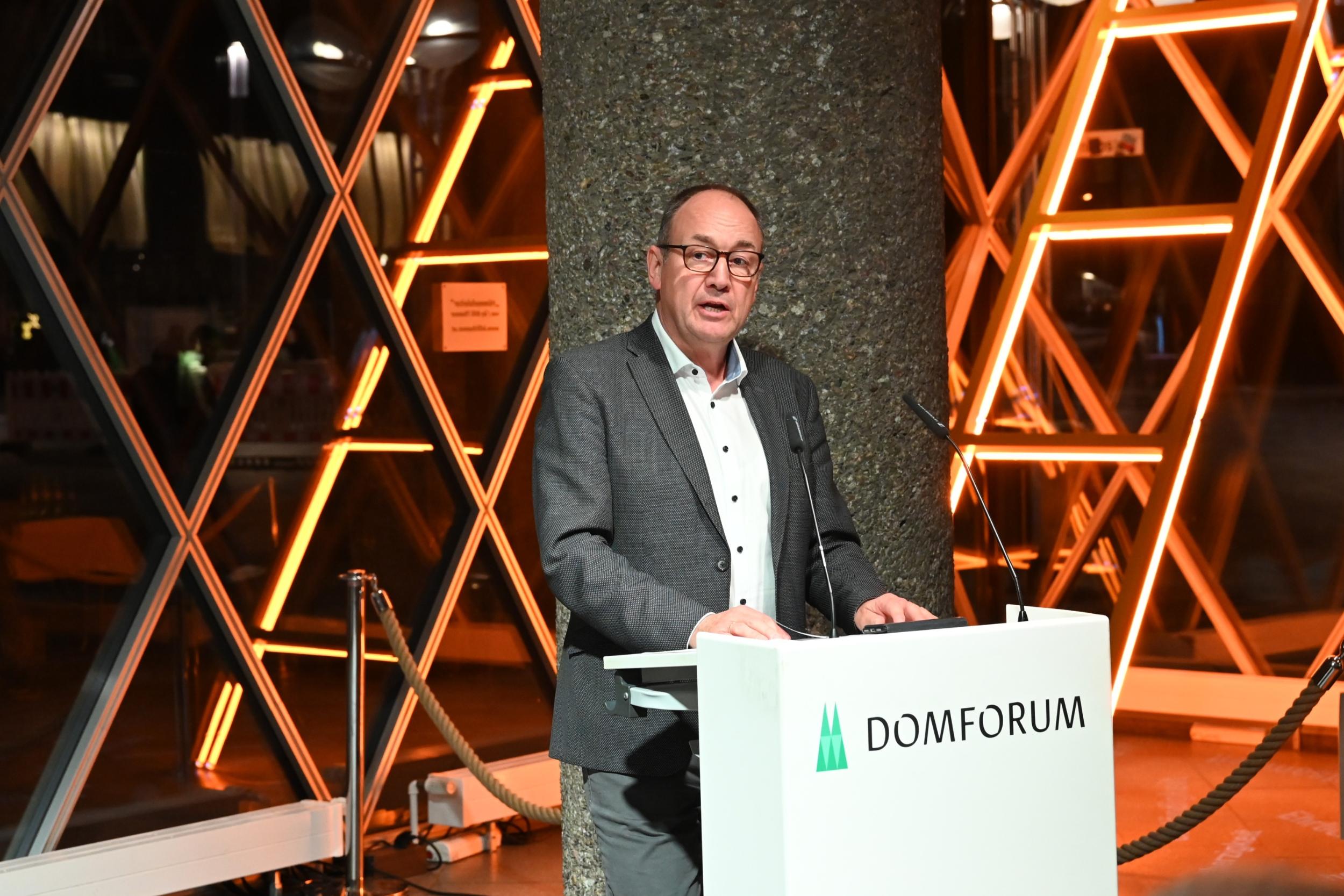 Rainer Tüschenbönner steht an einem Lesepult.